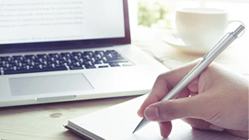 PCと紙とペンが置いてある様子