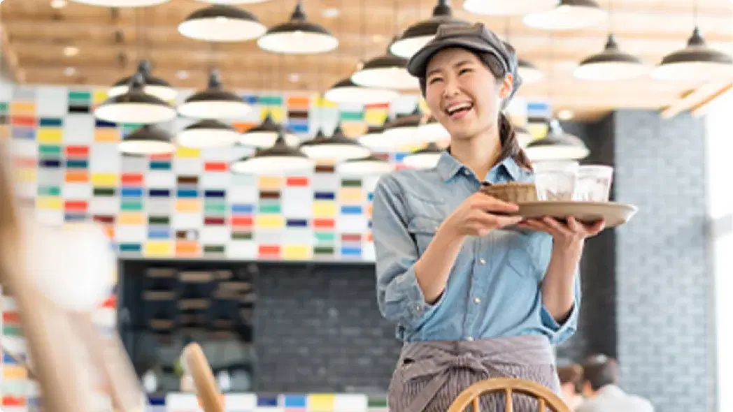 女の人が飲食店で水を運んでいる様子