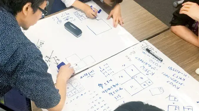 数人で用紙に数学の問題を解いている様子