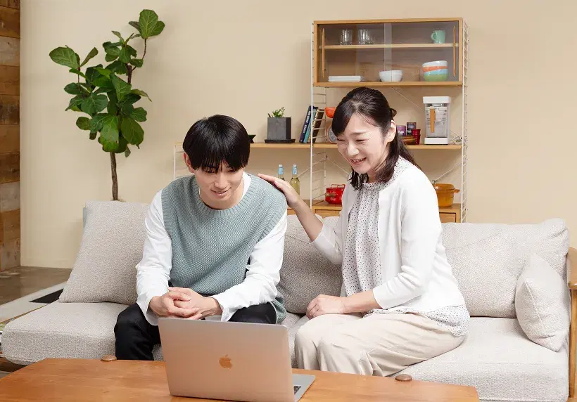 生徒と保護者がノートパソコンを見ながら面談をしている様子