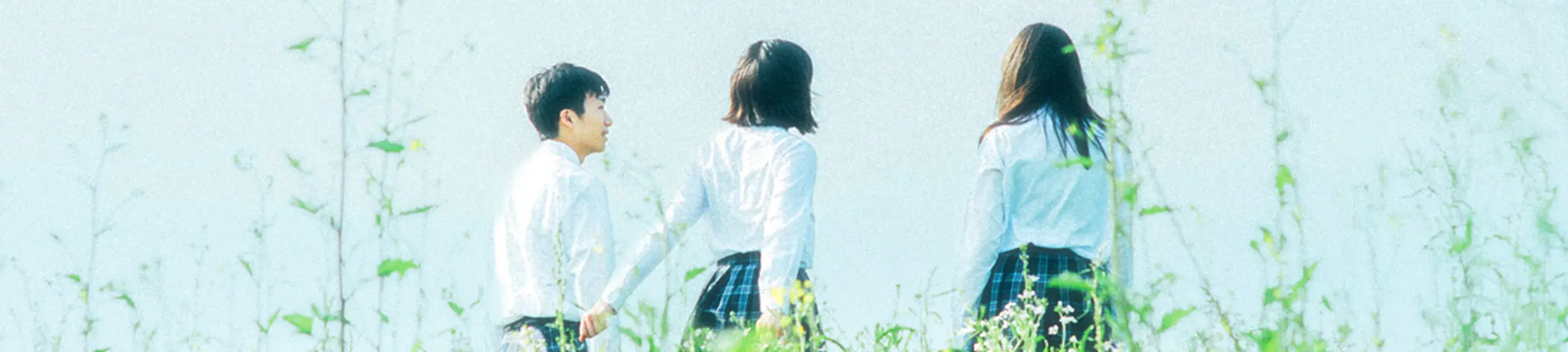 3人の生徒が青空の下で話している様子